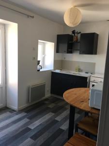 una pequeña cocina con mesa de madera y comedor en Family, en La Réorthe