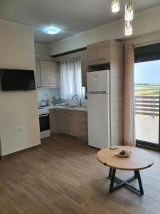 een keuken met een witte koelkast en een tafel bij Island View Apartments in Moúdhros