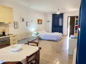 una cucina e un soggiorno con letto e tavolo di Il Terrazzo - Galatea casa vacanze a Gagliano del Capo