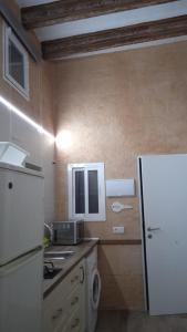 a kitchen with a white refrigerator and a sink at Apartamento Barrio Alto in Sanlúcar de Barrameda