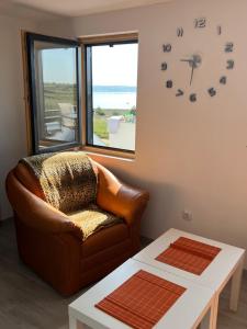 a living room with a couch and a clock on the wall at Apartments Linic in Nin