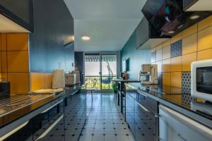 cocina grande con paredes azules y azulejos amarillos en Le Studio Enchanté - Vue Magique de Montrichard, en Montrichard