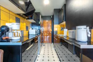cocina grande con encimeras y paredes amarillas y negras en Le Studio Enchanté - Vue Magique de Montrichard, en Montrichard