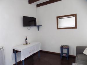 ein Wohnzimmer mit einem Tisch und einer Flasche Wein darauf in der Unterkunft La maisonnette in Les Adjots