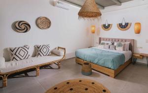 a bedroom with two beds and a couch at The Cave Villa in Matala