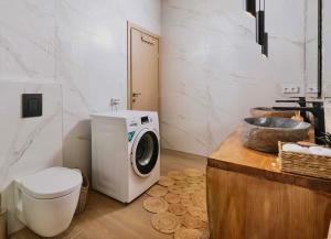 a bathroom with a washing machine and a toilet at The Cave Villa in Matala
