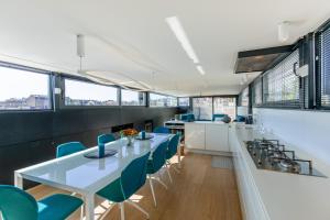 a dining room with a long table and blue chairs at Péniche de prestige à Namur avec vue sur la Citadelle - A l'Abordage - By Voyages Copine in Namur