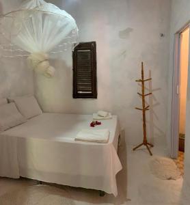 a white room with a bed and a table at Casa Branca in Atins