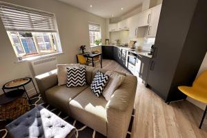 a living room with a couch and a kitchen at Stylish and Modern One-Bedroom Flat in Dorset in Parkstone