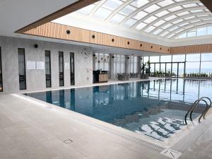 a large swimming pool in a building with a glass ceiling at Paradise Apartments Batumi in Batumi