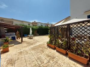 un patio con macetas y una valla en Noto Sole di Sicilia, en Marina di Noto