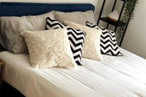 a bed with black and white pillows on it at Stylish and Modern One-Bedroom Flat in Dorset in Parkstone