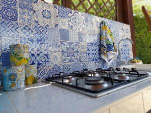 a stove top with a blue and white tile back splash at Noto Sole di Sicilia in Noto Marina