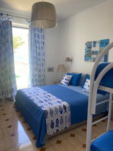 ein Schlafzimmer mit einem blauen Bett und einem Fenster in der Unterkunft villa martina apartament in Ischia