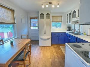 a kitchen with blue cabinets and a white refrigerator at Upper Unit - 4 blocks to the beach, restaurant, and bar district - great deck! in Jacksonville Beach