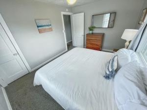 a bedroom with a white bed and a mirror at Upper Unit - 4 blocks to the beach, restaurant, and bar district - great deck! in Jacksonville Beach