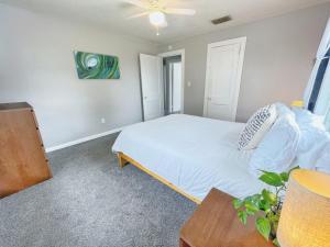 a bedroom with a white bed and a table at Upper Unit - 4 blocks to the beach, restaurant, and bar district - great deck! in Jacksonville Beach