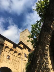 Un edificio antiguo con una torre en el cielo. en Fattoria Guicciardini, en San Gimignano