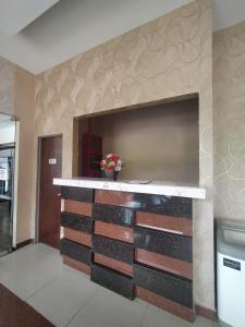 een open haard in een kamer met een muur bedekt met tegels bij Alia Express Sendayan in Kampong Baharu Jimah