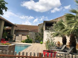 une arrière-cour avec une piscine et une maison dans l'établissement Appartement + terrasse à 5 mn de Carcassonne, à Pezens