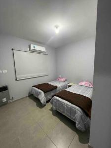 2 camas en una habitación con una pared blanca en Único Depto Próximo a la Barraca by Inside en Guaymallén