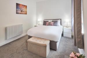 Host & Stay - Britton Hall Bungalow في Westgate: غرفة نوم مع سرير أبيض كبير ومقعد