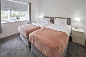 Host & Stay - Britton Hall Bungalow في Westgate: سريرين في غرفة الفندق مع نافذة