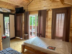 a bedroom with a bed in a room with wooden walls at Cypress House in Novy Afon