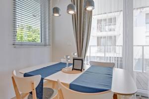 a dining room with a table with a laptop on it at Flatbook - Seaside Apartments Tre Mare in Gdańsk