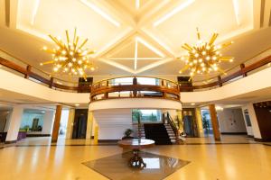 un gran vestíbulo con 2 lámparas de araña y una mesa en Grand Carimã Resort & Convention Center, en Foz do Iguaçu