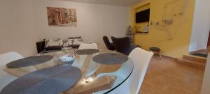 uma sala de jantar com uma mesa de vidro e cadeiras em Angelo Apartment Center of Split em Split