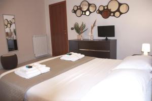 een slaapkamer met een groot bed en handdoeken bij Le Muse in Caserta