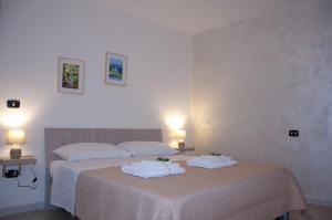 1 Schlafzimmer mit 2 Betten mit weißer Bettwäsche und Handtüchern in der Unterkunft Le Muse in Caserta