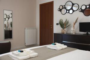 ein Schlafzimmer mit einem Bett mit Handtüchern darauf in der Unterkunft Le Muse in Caserta