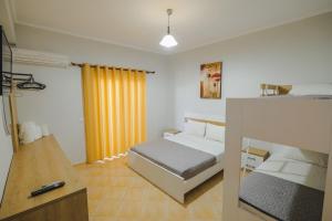 a bedroom with a bed and a yellow curtain at Hotel Milo Ksamil in Ksamil