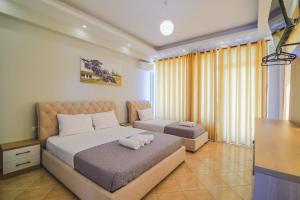 Dormitorio con cama, escritorio y TV en Hotel Milo Ksamil en Ksamil