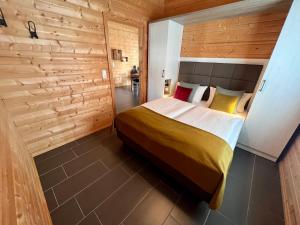 ein Schlafzimmer mit einem Bett und einer Holzwand in der Unterkunft Ferienhaus Nordland in Bachenbrock