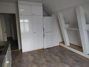 una cocina con armarios blancos y una escalera en Kivijärven Linnanmäki Apartments, en Kivijärvi