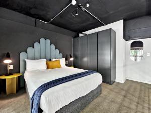 a bedroom with a large bed with a blue headboard at BlackBrick Cape Town Foreshore in Cape Town +50 photos