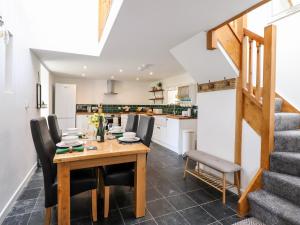 uma cozinha e sala de jantar com uma mesa de madeira e cadeiras em Ysgubor Craig Y Gronfa em Machynlleth