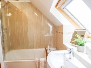 uma casa de banho com uma banheira e um lavatório em Ysgubor Craig Y Gronfa em Machynlleth