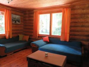 - un salon avec deux canapés bleus et des rideaux orange dans l'établissement Guest House Lēveri, à Valgalciems
