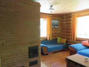 a living room with a brick wall and two blue couches at Guest House Lēveri in Valgalciems