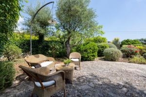 um grupo de cadeiras e uma mesa num quintal em Trullo La Vecchia Elce with garden em Locorotondo