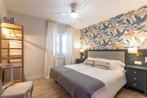 Un dormitorio con una cama grande con una pared floral. en Hola Bilbao!, en Bilbao
