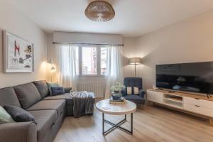 Una sala de estar con un sofá y un televisor. en Hola Bilbao!, en Bilbao