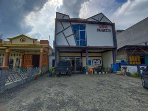 um edifício com um camião estacionado em frente dele em OYO 92591 Wisma Pangestu Syariah em Ujungtanjung