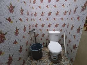 baño con aseo y cubo de basura en OYO 92591 Wisma Pangestu Syariah, en Ujungtanjung