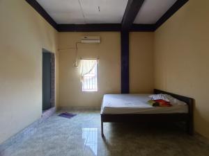 1 dormitorio con 1 cama en una habitación con ventana en OYO 92591 Wisma Pangestu Syariah en Ujungtanjung