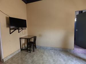 Habitación con mesa y TV en la pared. en OYO 92591 Wisma Pangestu Syariah, en Ujungtanjung